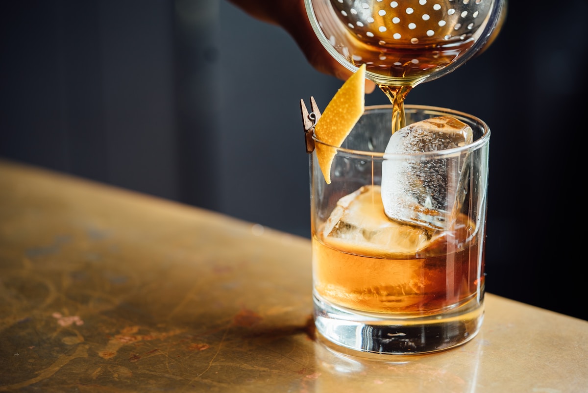 Bourbon glass on bar, unsaid words
