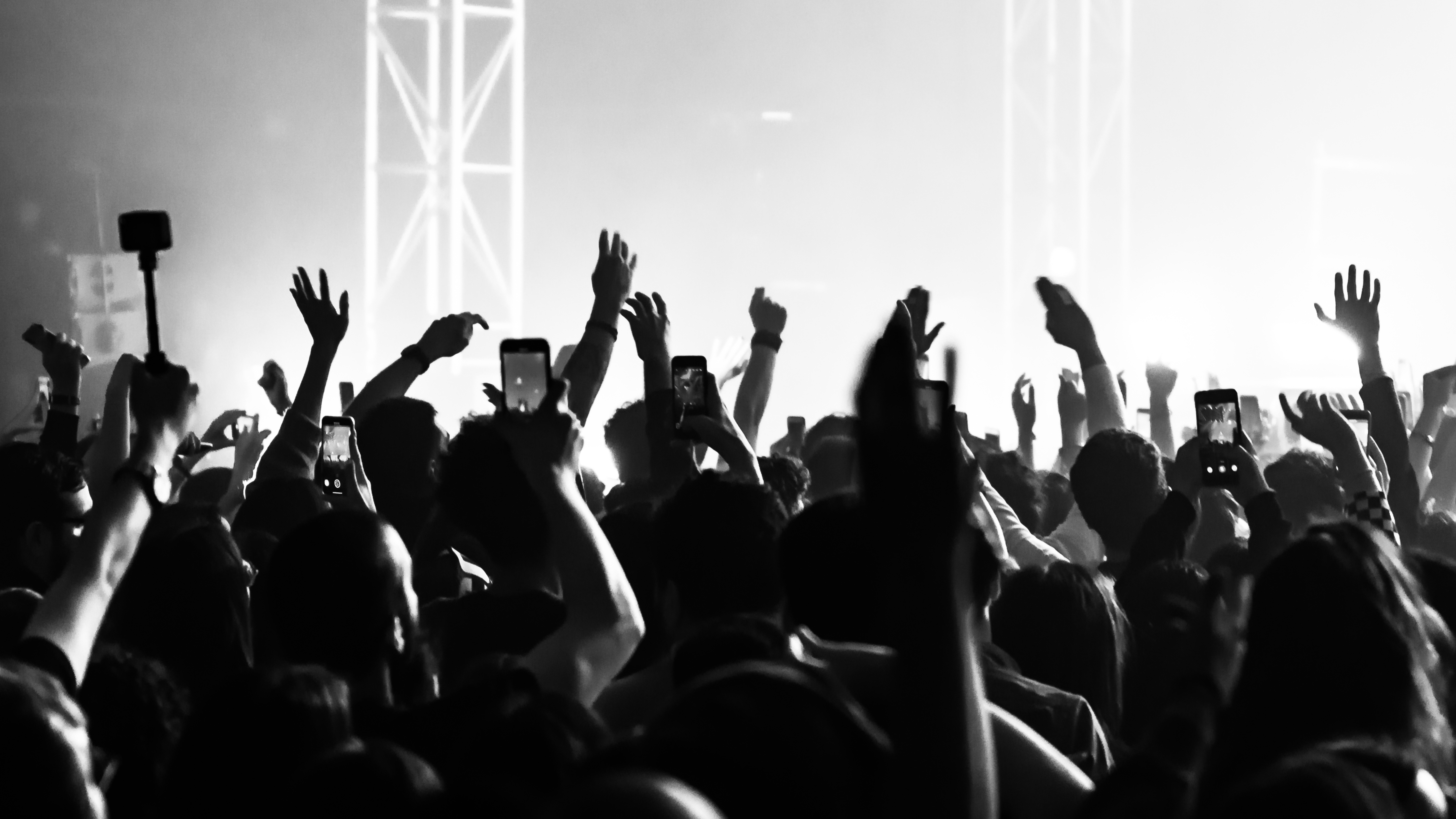 A crowd with hands to the sky at a live concert