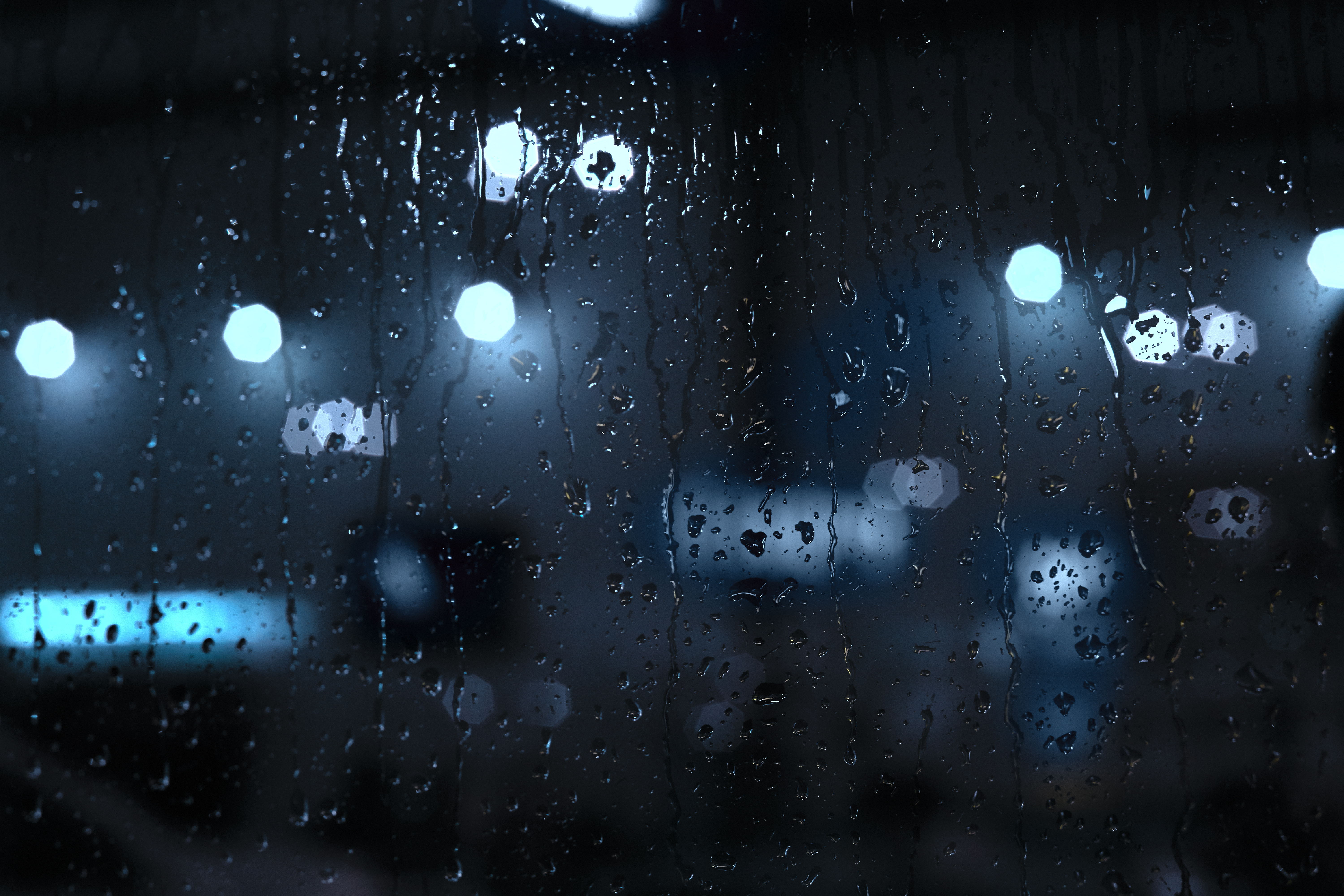Rain drops on a window with night street lights